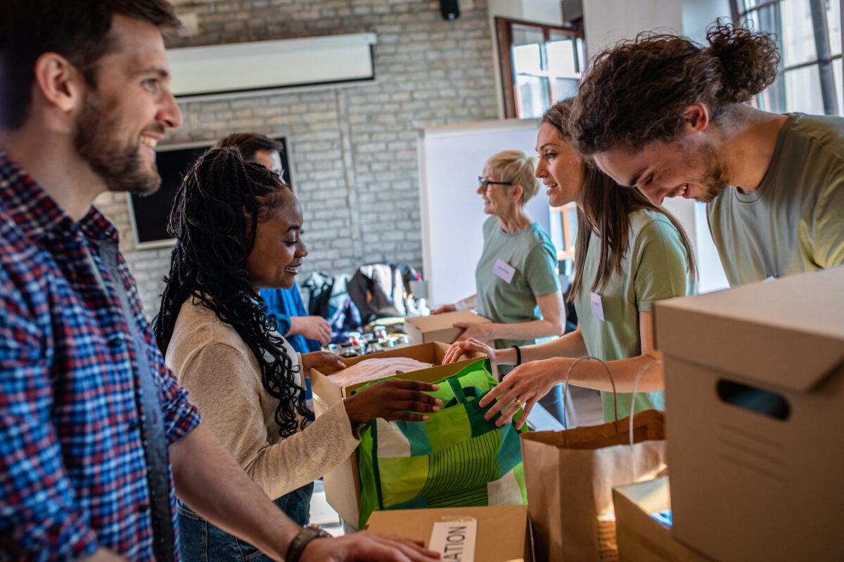group of people giving back at a donation drive, boxing up donations and handing them over a table