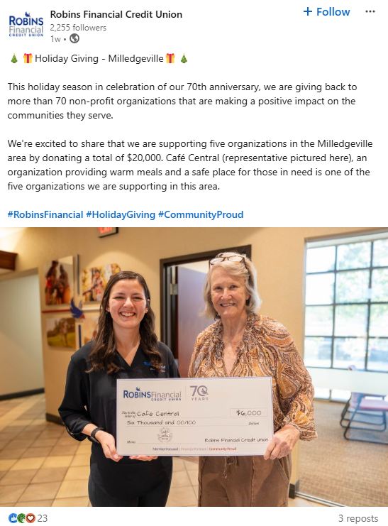 robins financial credit union giving back example: two women standing together holding a big check and smiling